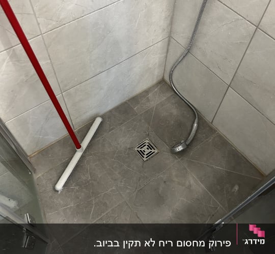 מקלחת עם צינור מים וניקוז ברצפה